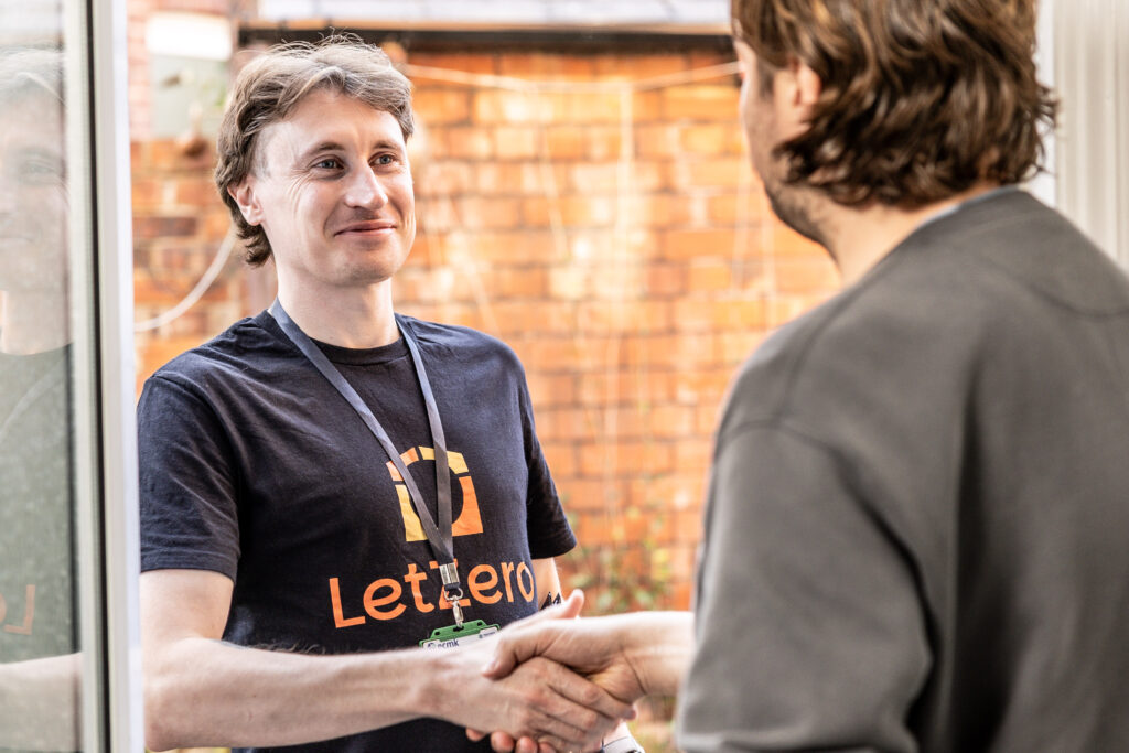 A member of the Let Zero team and a customer shake hands